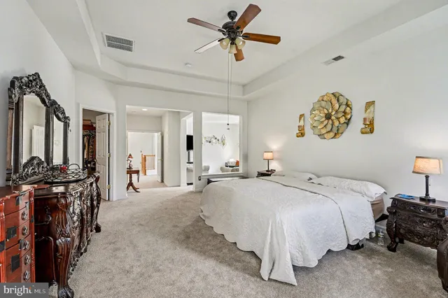 a spacious bedroom with a bed and ceiling fan