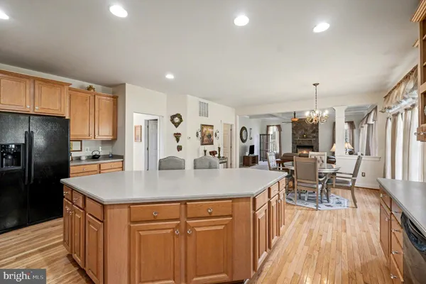 a kitchen with stainless steel appliances granite countertop a refrigerator a table and chairs