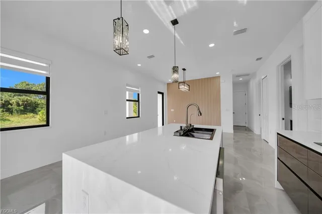 a view of a kitchen with a sink and chandelier