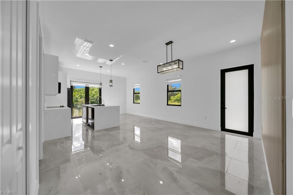 713 Roma Avenue South Lehigh Acres, FL 33974 - Photo 13 of 38 a view of a hallway with a dining table and chairs