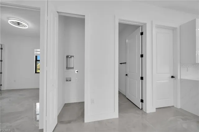 a view of an empty room with closet and mirror