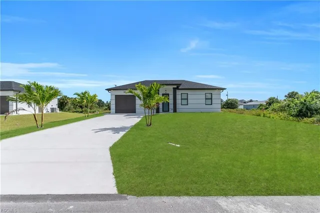 a view of a house with a yard and potted plants