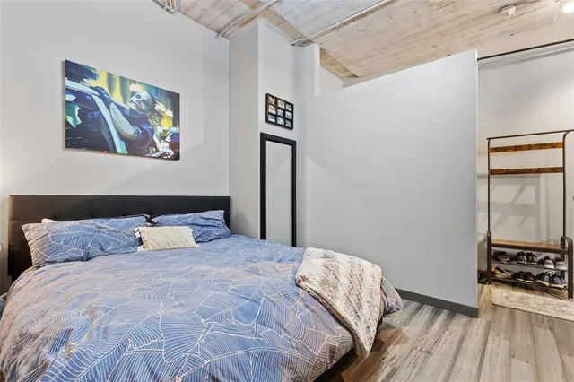 a bedroom with a bed and a table with wooden floor