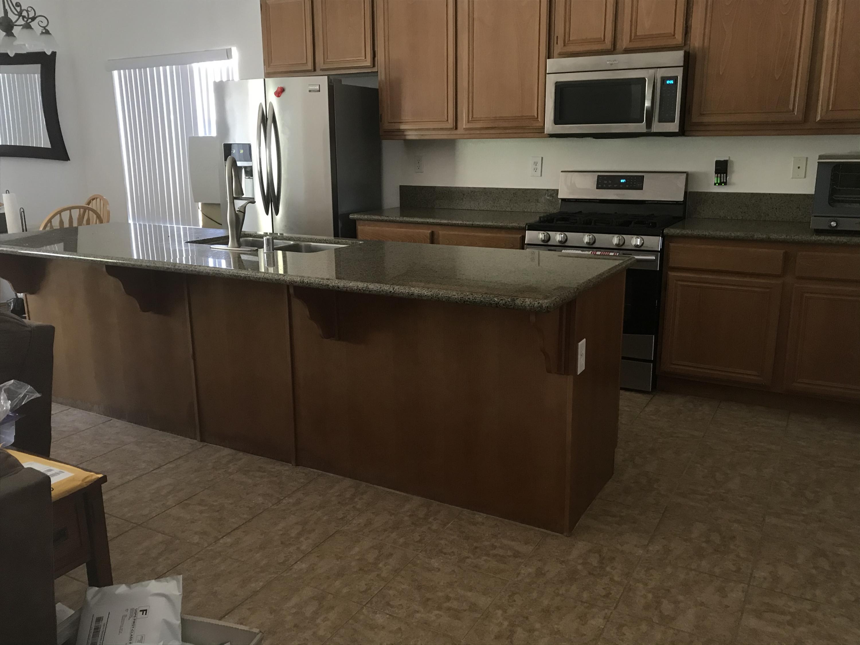 67874 Rio Largo Road Cathedral City, CA 92234 - Photo 7 of 20 a kitchen with stainless steel appliances granite countertop a refrigerator a stove a sink and a microwave
