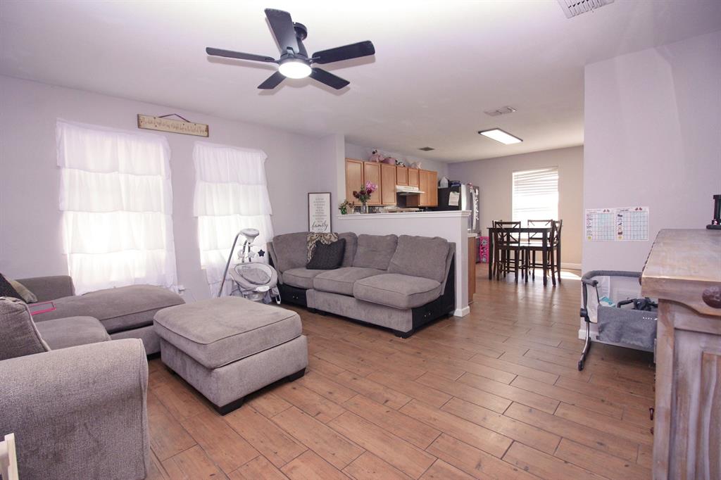 12609 Carpenter Lane Rhome, TX 76078 - Photo 2 of 29 Wood-finish flooring throughout, ceiling fan with integrated lighting, recessed lighting, kitchen featuring wood cabinetry, dining space with window