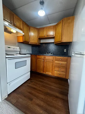 a kitchen with stainless steel appliances granite countertop wooden cabinets a stove a sink and dishwasher