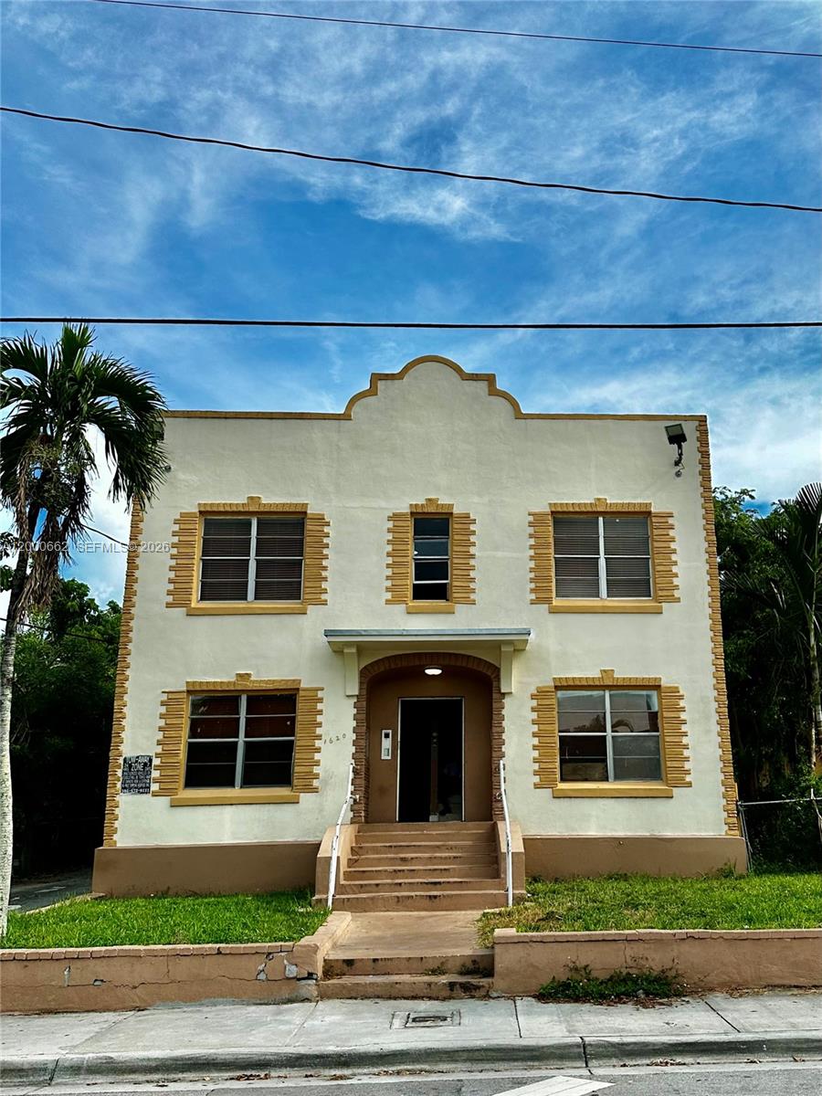 1620 Northwest 3rd Street, Unit 6 Miami, FL 33125 - Photo 1 of 1 a front view of a house with garage and yard