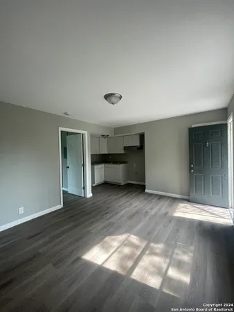 a view of empty room with wooden floor and window