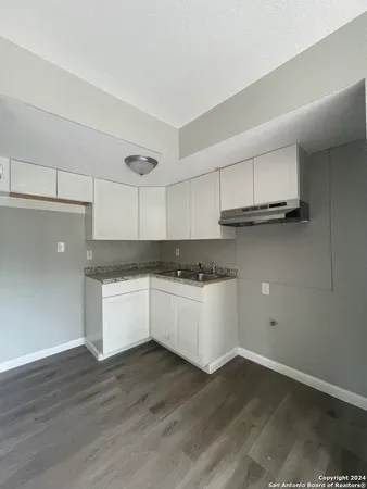 a kitchen with granite countertop white cabinets and white appliances