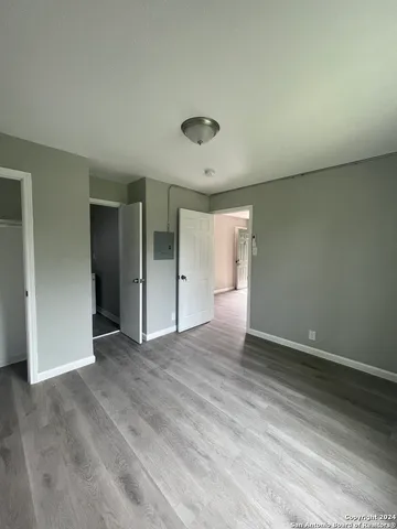 an empty room with wooden floor and natural light