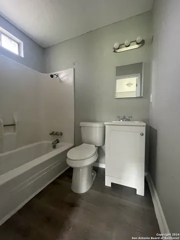 a white toilet sitting next to a bathroom sink and tub