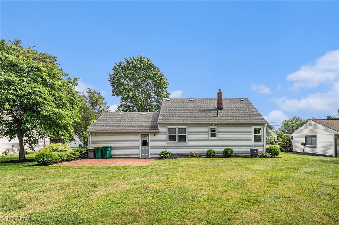 194 Prentice Road Painesville, OH 44077 - Photo 16 of 21 Rear view of house featuring a lawn, a patio, a chimney, and roof with shingles