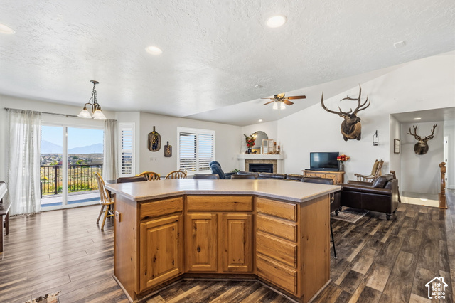 9044 North Cedar Pass Road Eagle Mountain, UT 84005 - Photo 11 of 63 Spacious open-concept interior featuring vaulted ceilings, wood-finish flooring, and a kitchen island with built-in storage