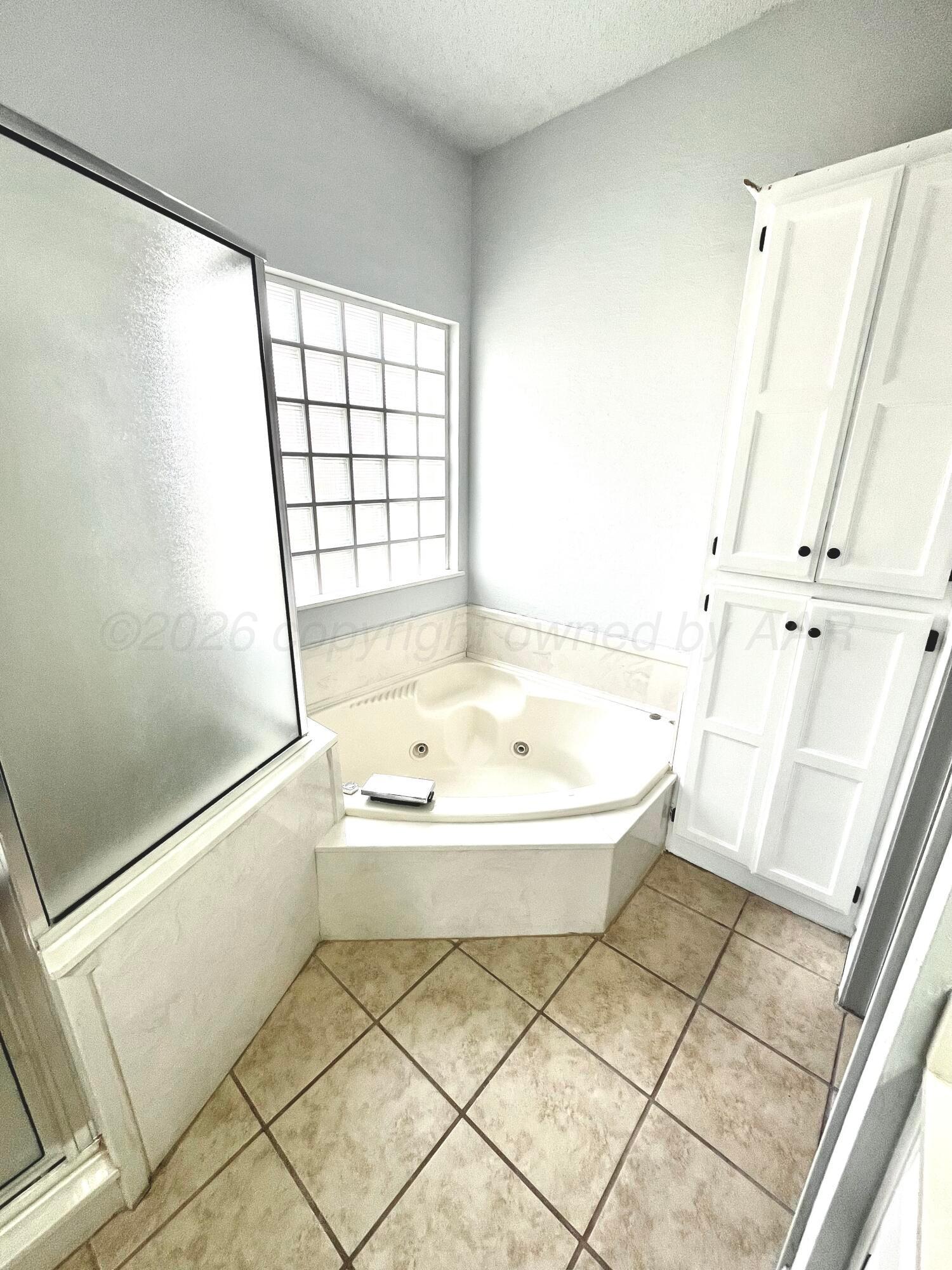 7628 Catskill Avenue Amarillo, TX 79121 - Photo 11 of 16 a bathroom with a bathtub and a shower