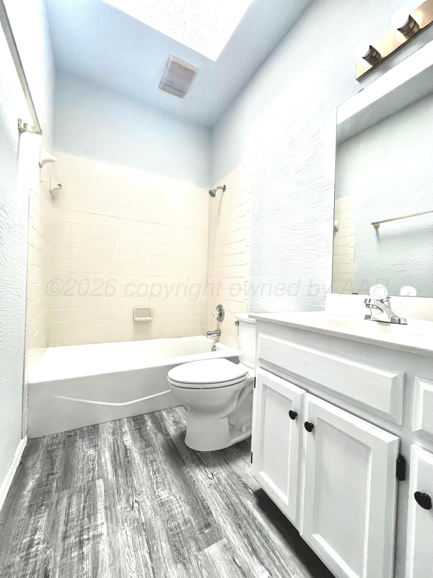 7628 Catskill Avenue Amarillo, TX 79121 - Photo 16 of 16 a bathroom with a double vanity sink toilet mirror and bathtub