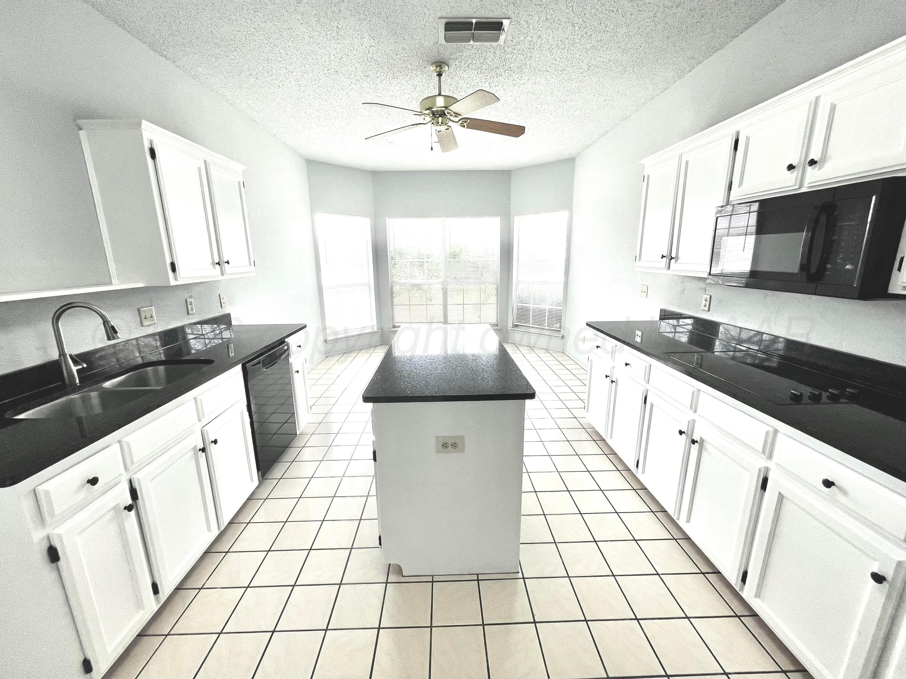 7628 Catskill Avenue Amarillo, TX 79121 - Photo 7 of 16 a kitchen with stainless steel appliances a sink a stove a refrigerator cabinets and a window