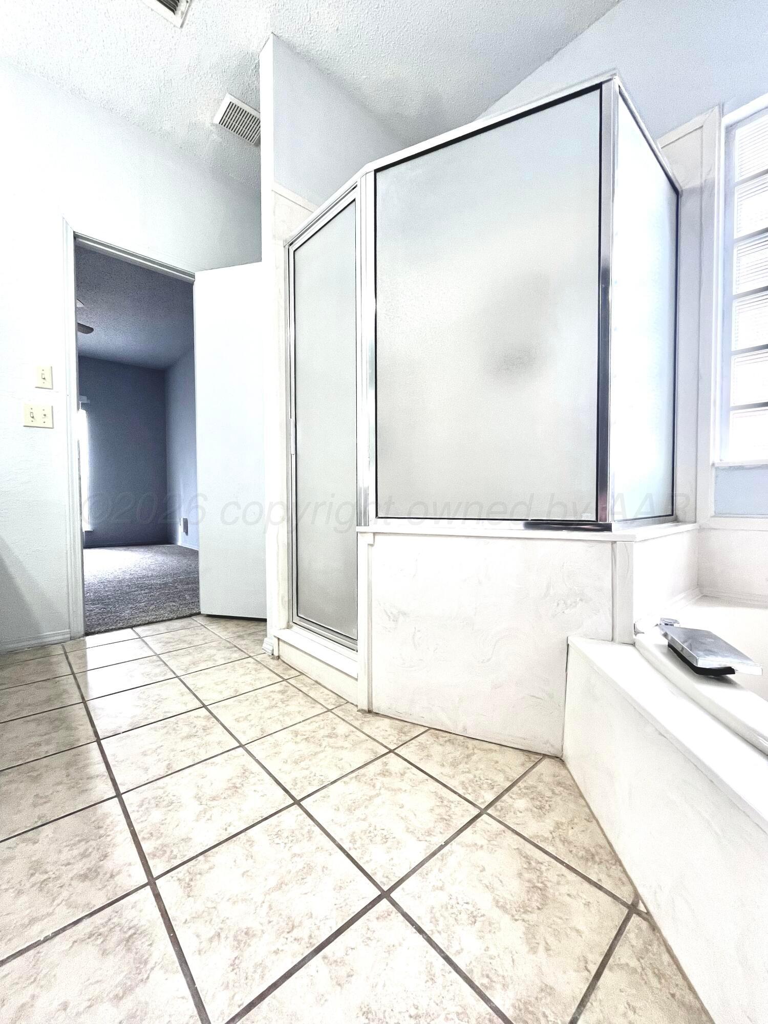 7628 Catskill Avenue Amarillo, TX 79121 - Photo 9 of 16 a bathroom with a bathtub and a shower
