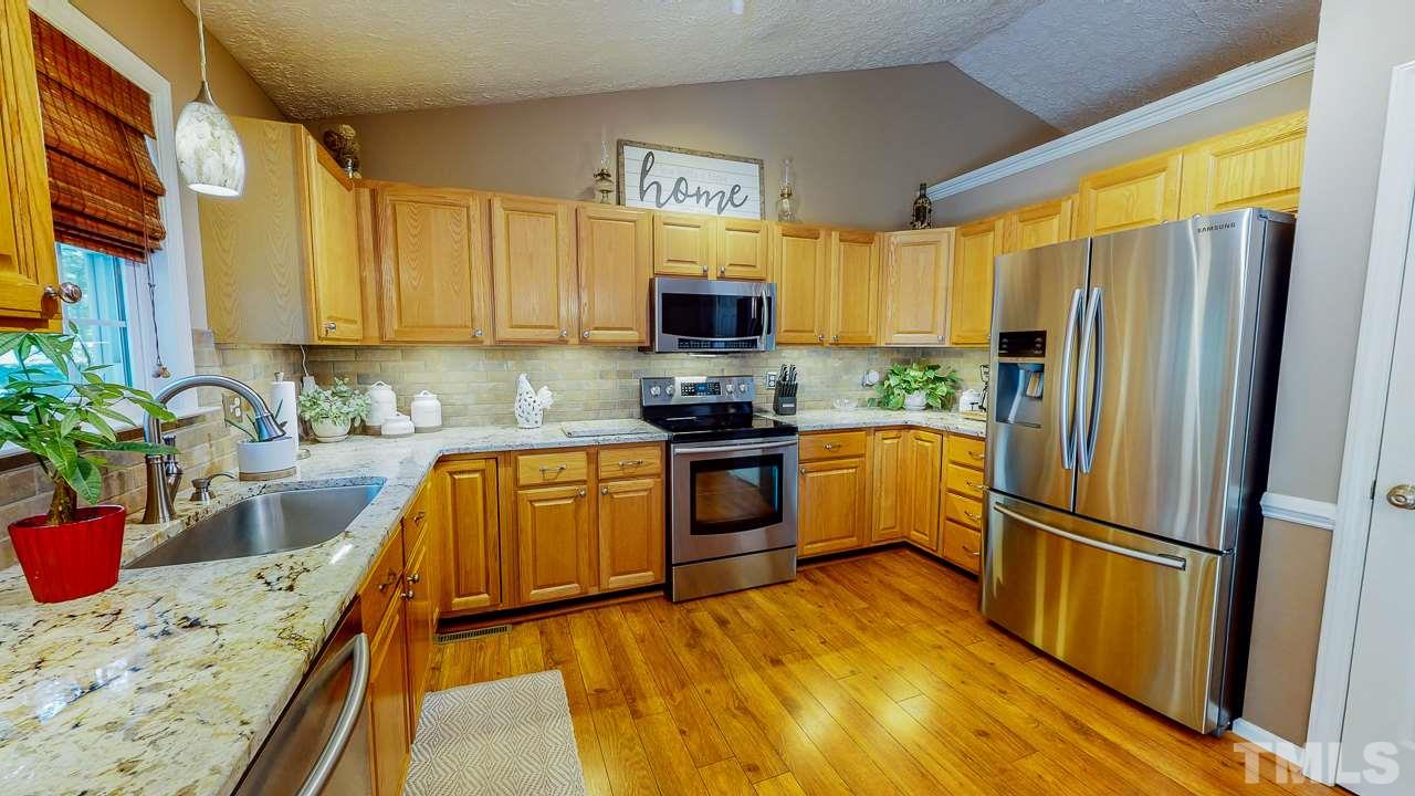 3612 Moriah Road Rougemont, NC 27572 - Photo 3 of 29 a kitchen with granite countertop a refrigerator a stove top oven a sink and dishwasher