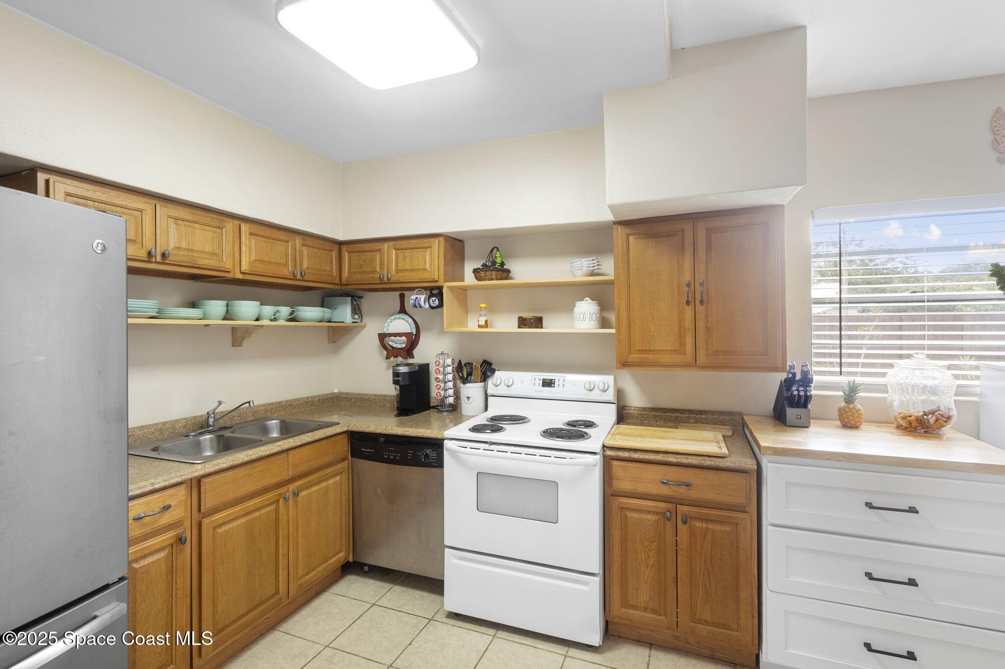 4535 Moon Road Titusville, FL 32780 - Photo 12 of 37 a kitchen with white cabinets stainless steel appliances and sink