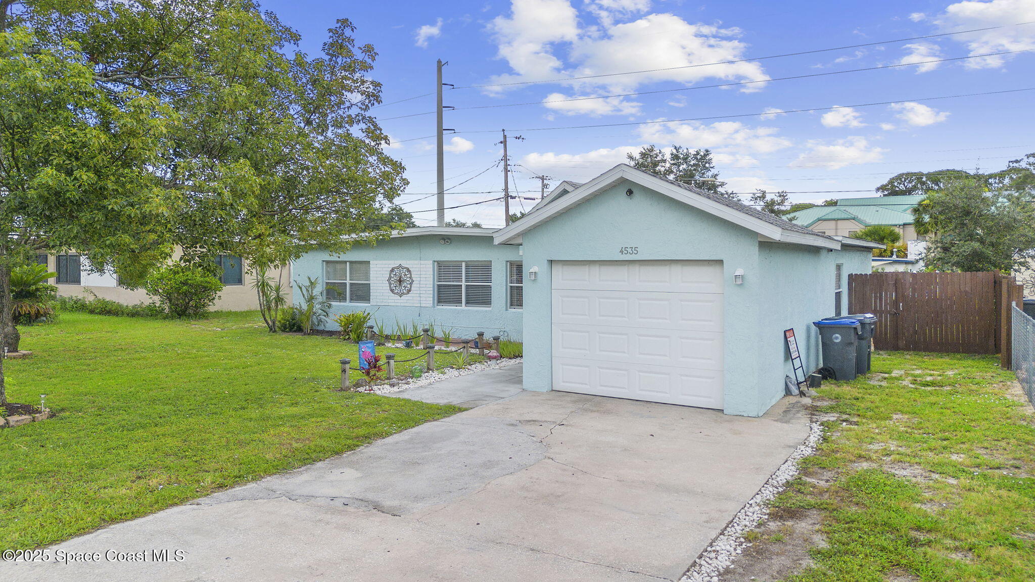 4535 Moon Road Titusville, FL 32780 - Photo 27 of 37 a front view of a house with a garden and yard