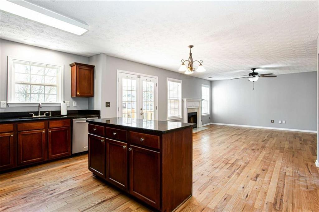 3721 Bogan Mill Road Northeast Buford, GA 30519 - Photo 12 of 58 a kitchen with granite countertop a sink cabinets and wooden floor