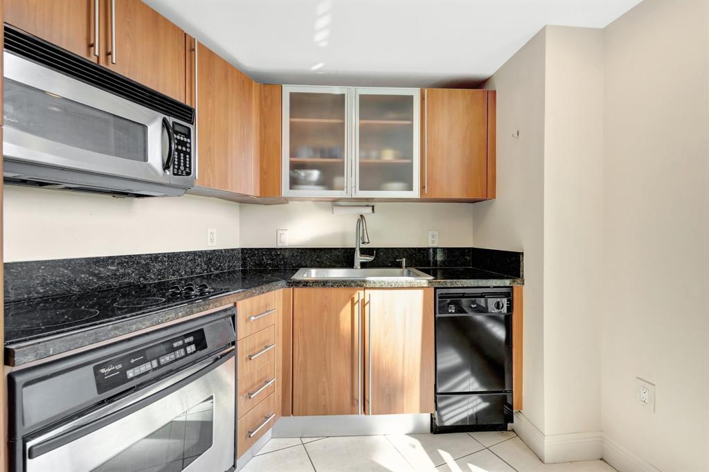 610 Clematis Street, Unit 412 West Palm Beach, FL 33401 - Photo 12 of 52 a kitchen with stainless steel appliances granite countertop a stove and a microwave