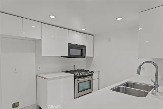 a kitchen with sink a microwave and cabinets