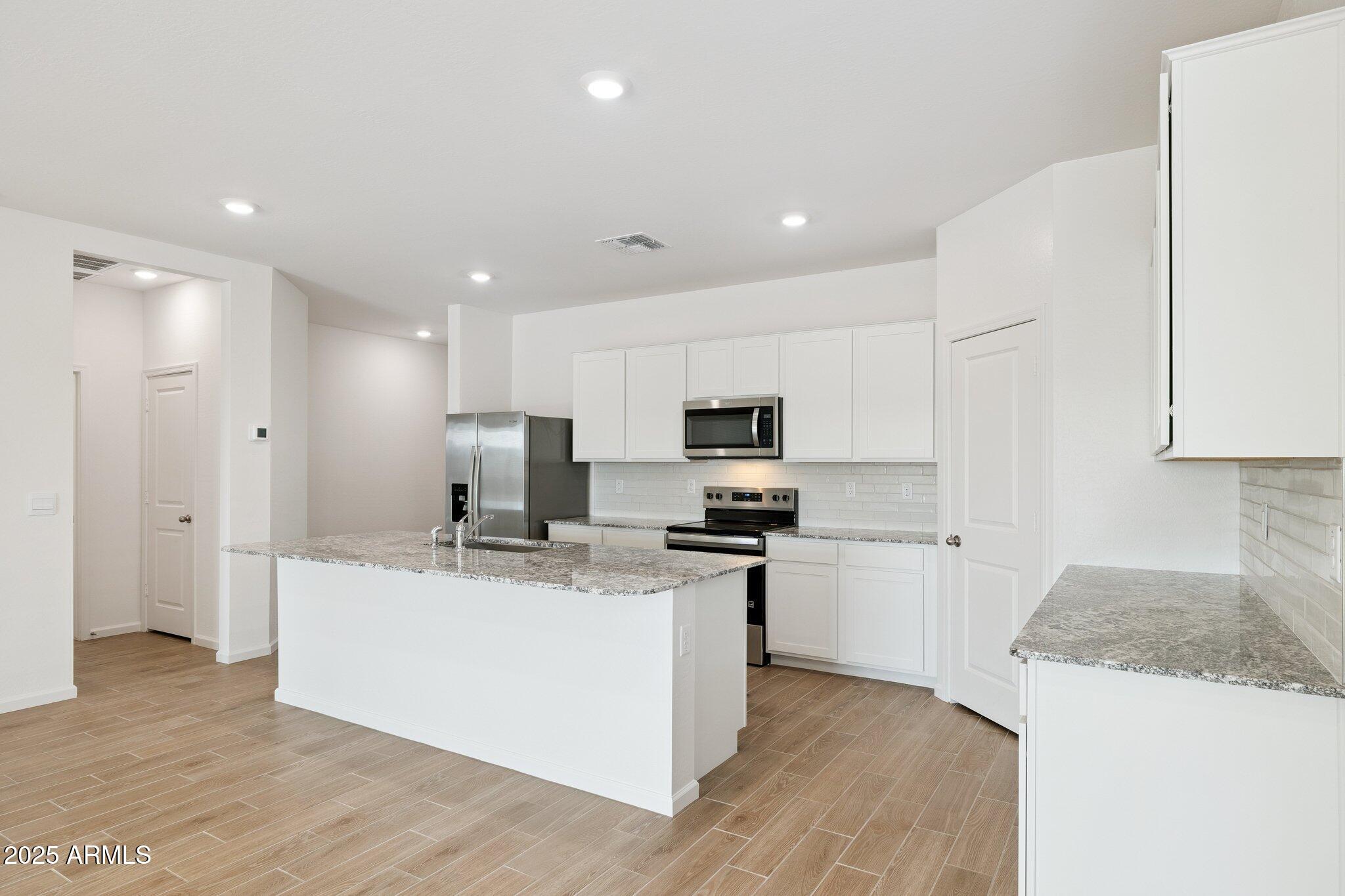 25459 West Fraktur Road Buckeye, AZ 85326 - Photo 5 of 14 a kitchen with stainless steel appliances granite countertop a sink stove and refrigerator