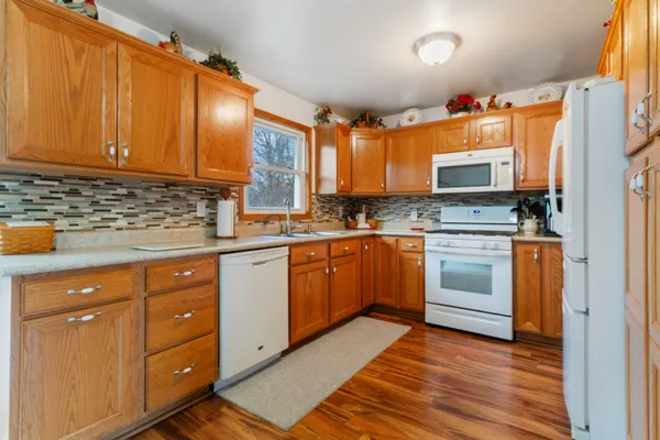 a kitchen with stainless steel appliances granite countertop a stove a sink dishwasher and a refrigerator