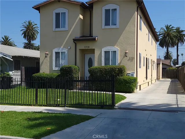 a view of a house with a yard and potted plants