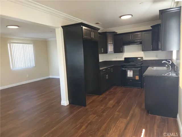 a kitchen with granite countertop a refrigerator and a sink
