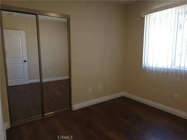 an empty room with wooden floor and entrance