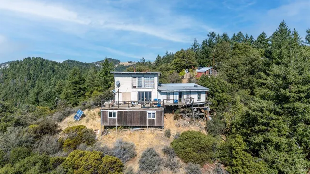 an aerial view of house with yard and trees around