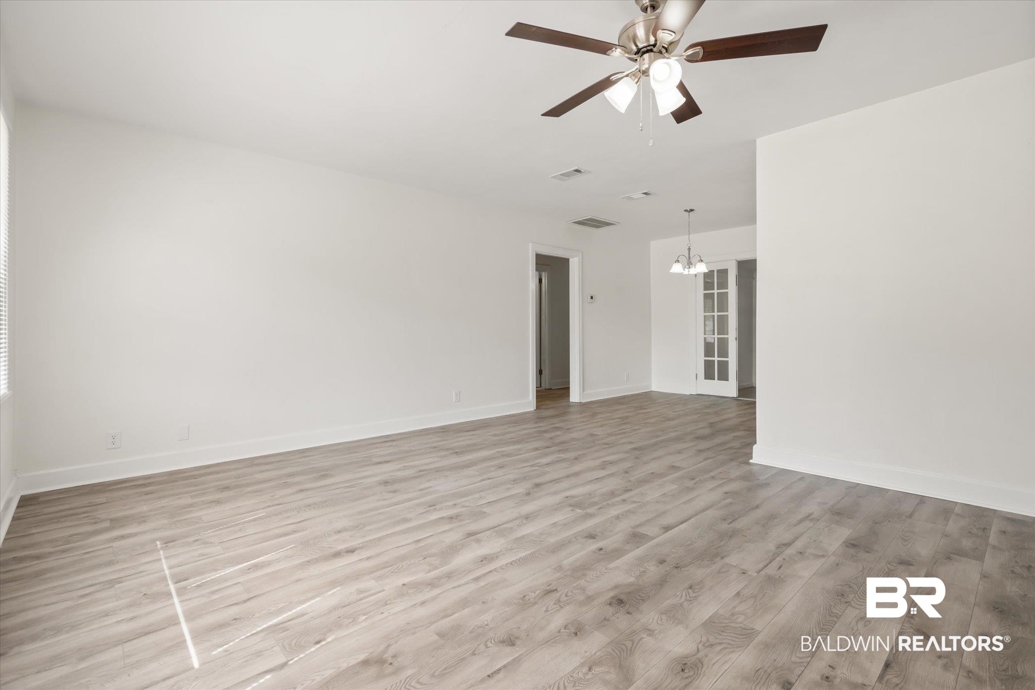 1306 Azalea Street Mobile, AL 36604 - Photo 3 of 20 Spare room featuring ceiling fan with notable chandelier and light hardwood / wood-style floors