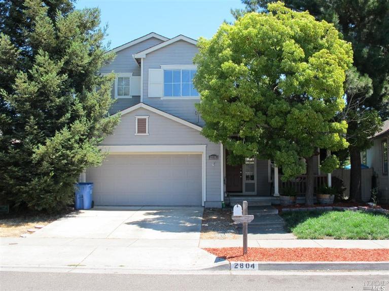 a view of a house with a yard and large tree