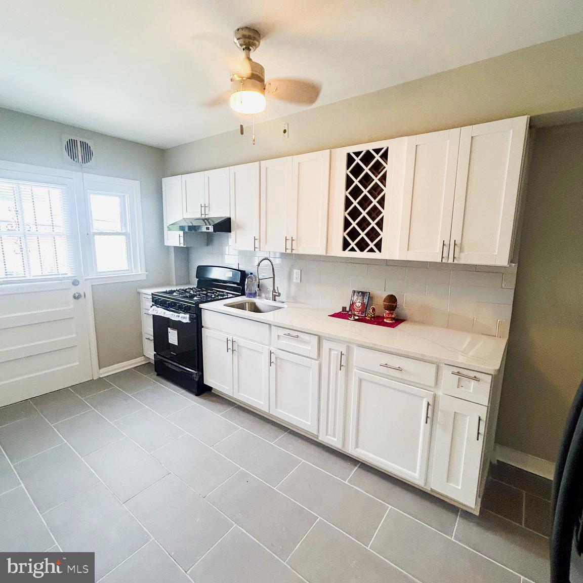 1260 Cedarcroft Road Baltimore, MD 21239 - Photo 6 of 18 a kitchen with a white cabinets and window