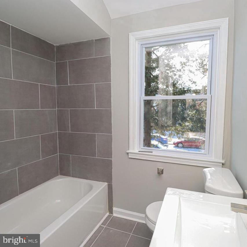 1260 Cedarcroft Road Baltimore, MD 21239 - Photo 8 of 18 a bathroom with a bathtub and window