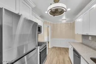 a kitchen with granite countertop a sink a stove and a refrigerator