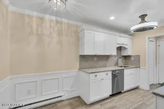 a kitchen with white cabinets and sink