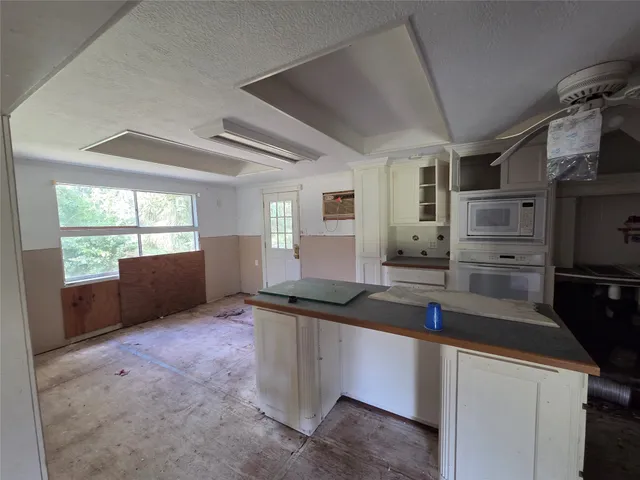 a kitchen with kitchen island granite countertop a sink and cabinets
