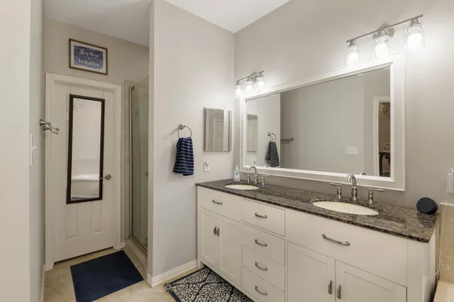 a bathroom with double sink and a mirror