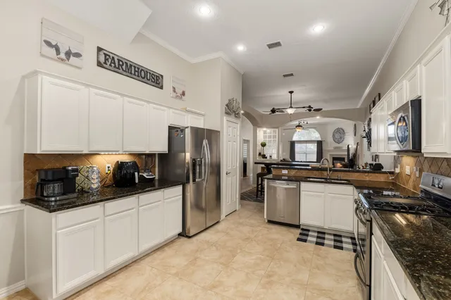 a kitchen with stainless steel appliances a stove a sink a refrigerator a microwave a stove and cabinets