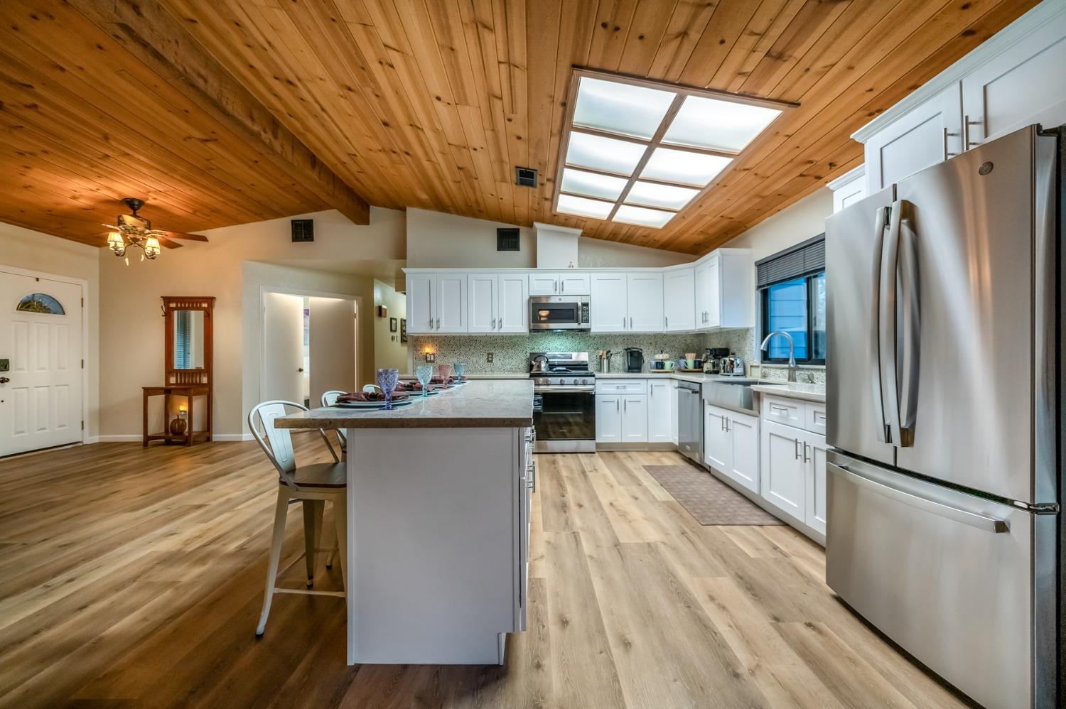 40984 Grouse Drive Three Rivers, CA 93271 - Photo 12 of 49 a kitchen with stainless steel appliances granite countertop a table chairs refrigerator and microwave