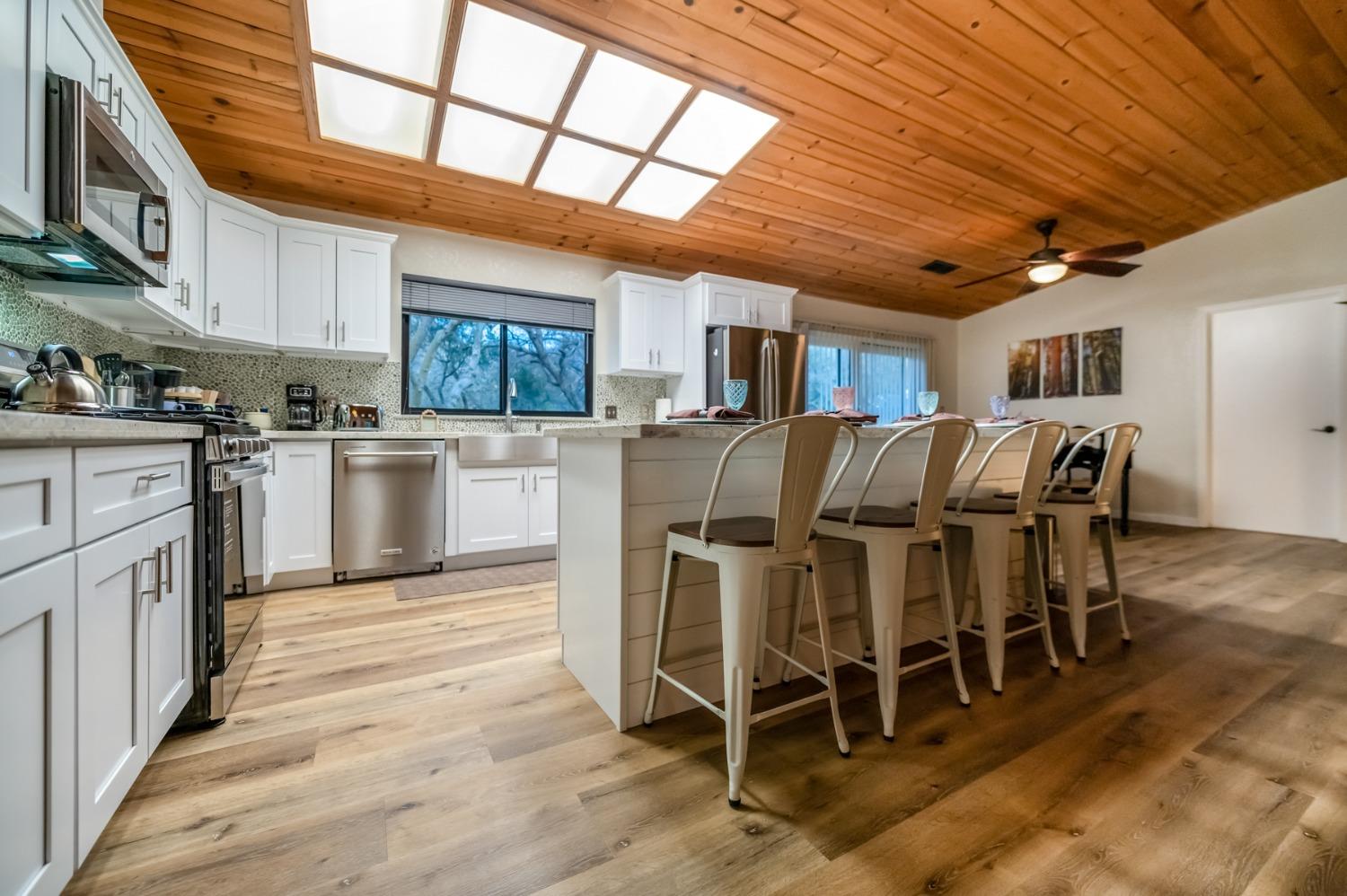 40984 Grouse Drive Three Rivers, CA 93271 - Photo 9 of 49 a kitchen with stainless steel appliances granite countertop wooden floors a stove and a sink