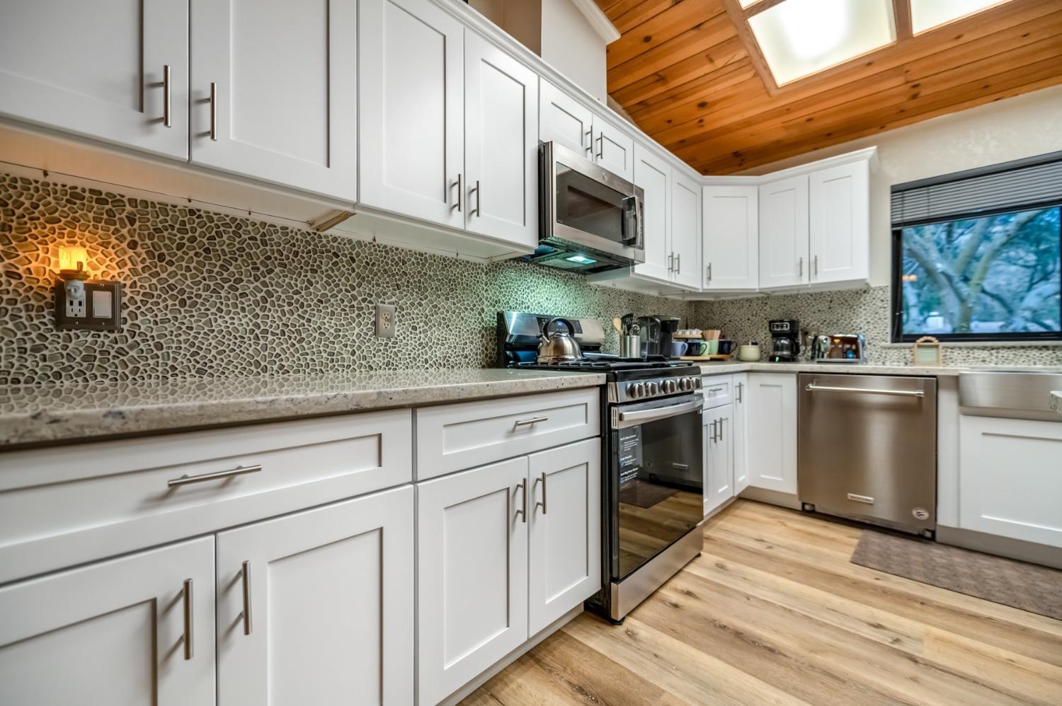 40984 Grouse Drive Three Rivers, CA 93271 - Photo 10 of 49 a kitchen with stainless steel appliances granite countertop a sink a stove top oven and white cabinets