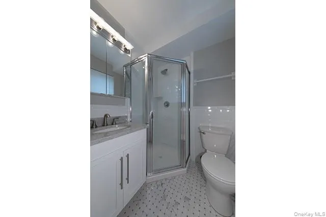a bathroom with a granite countertop toilet a sink a mirror and vanity