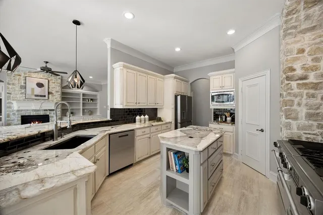 a kitchen with stainless steel appliances granite countertop a stove a sink and white cabinets