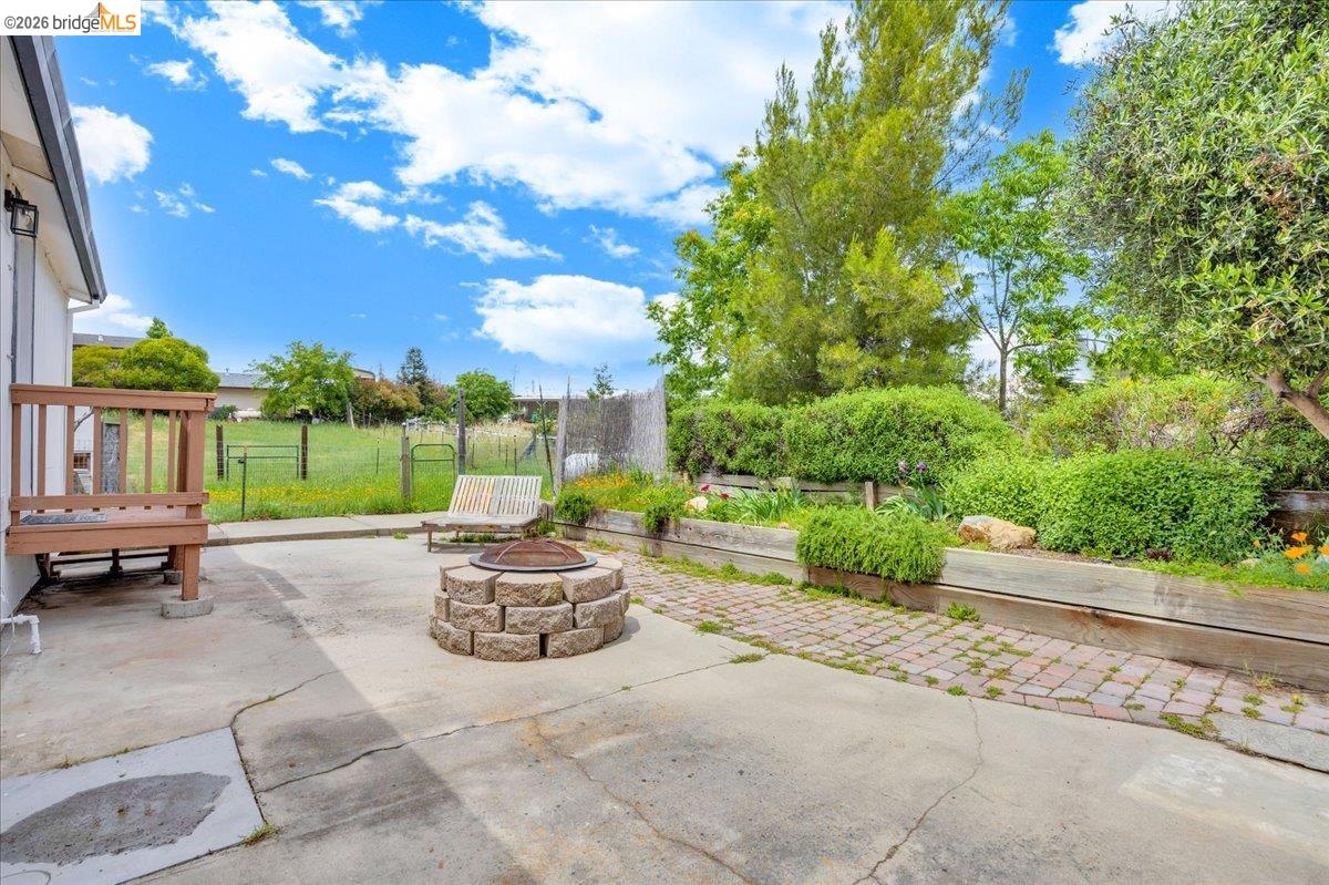 4419 Little John Road Copperopolis, CA 95228 - Photo 26 of 43 Expansive patio featuring a stone-block fire pit, concrete surfacing, and a brick-paver pathway