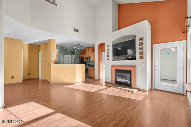 a view of a livingroom with a fireplace cabinet and windows