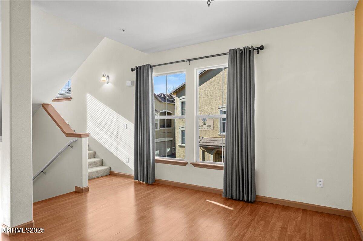 9050 Double R Boulevard, Unit 821 Reno, NV 89521 - Photo 9 of 20 a view of an empty room with wooden floor and a window